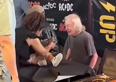 Angus Young assina bebê durante encontro com fãs no Canadá